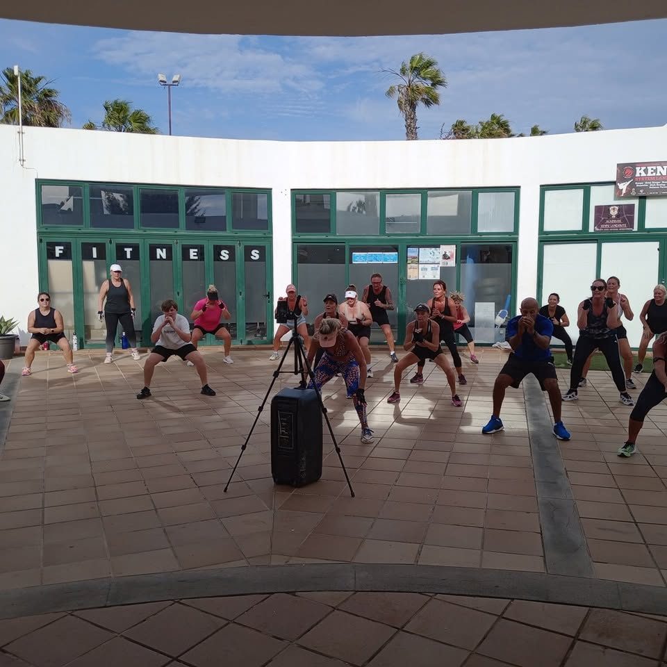 Fitness class doing squats in the Finchy Fitness courtyard, Playa Blanca