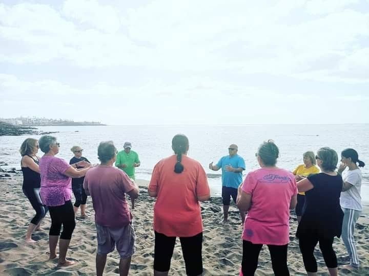 Tai Chi class in a circle on Natura Beach, Playa Blanca